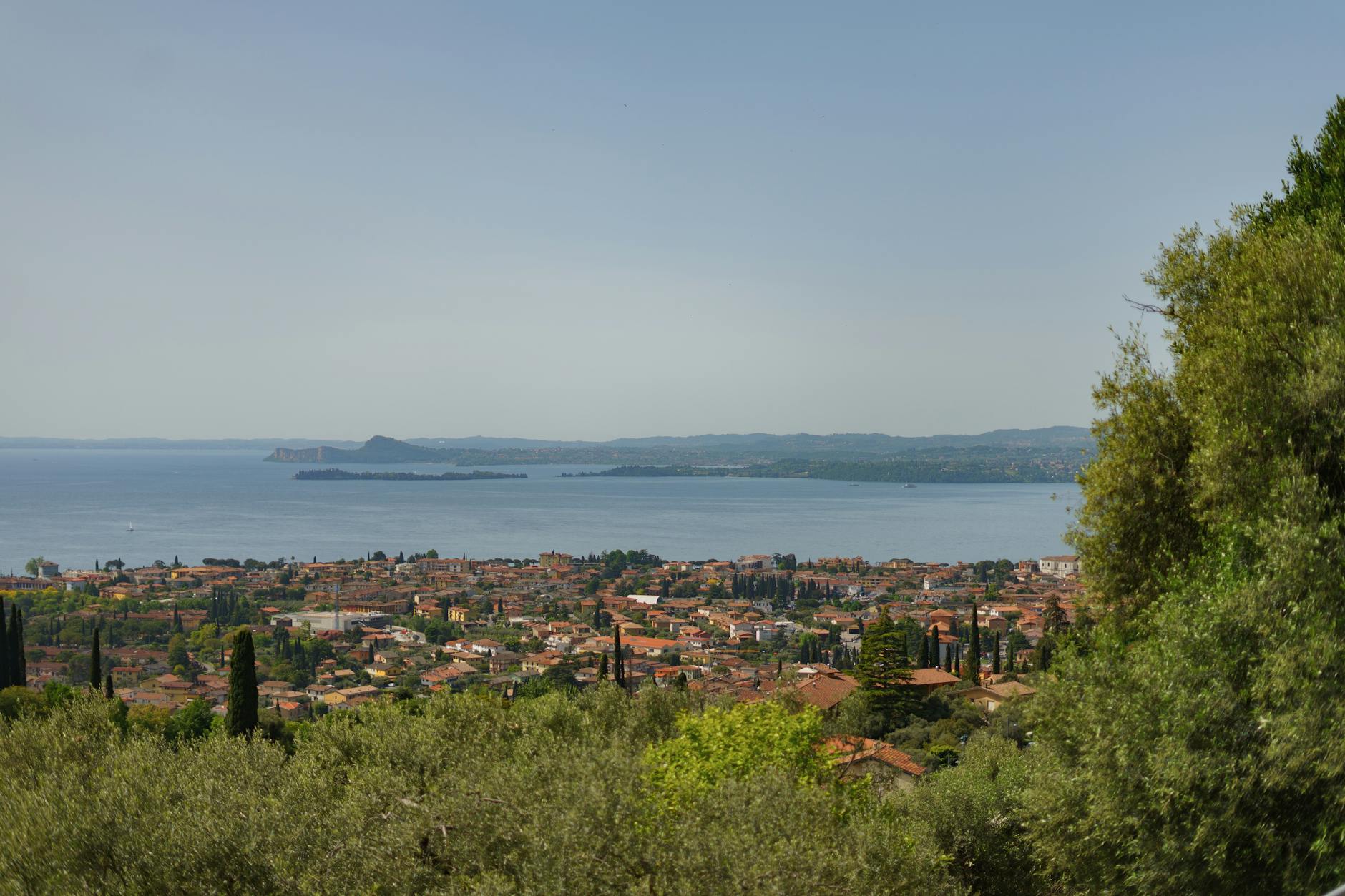 Panorama spokojnego miasteczka nad jeziorem otoczonego zielonymi wzgórzami