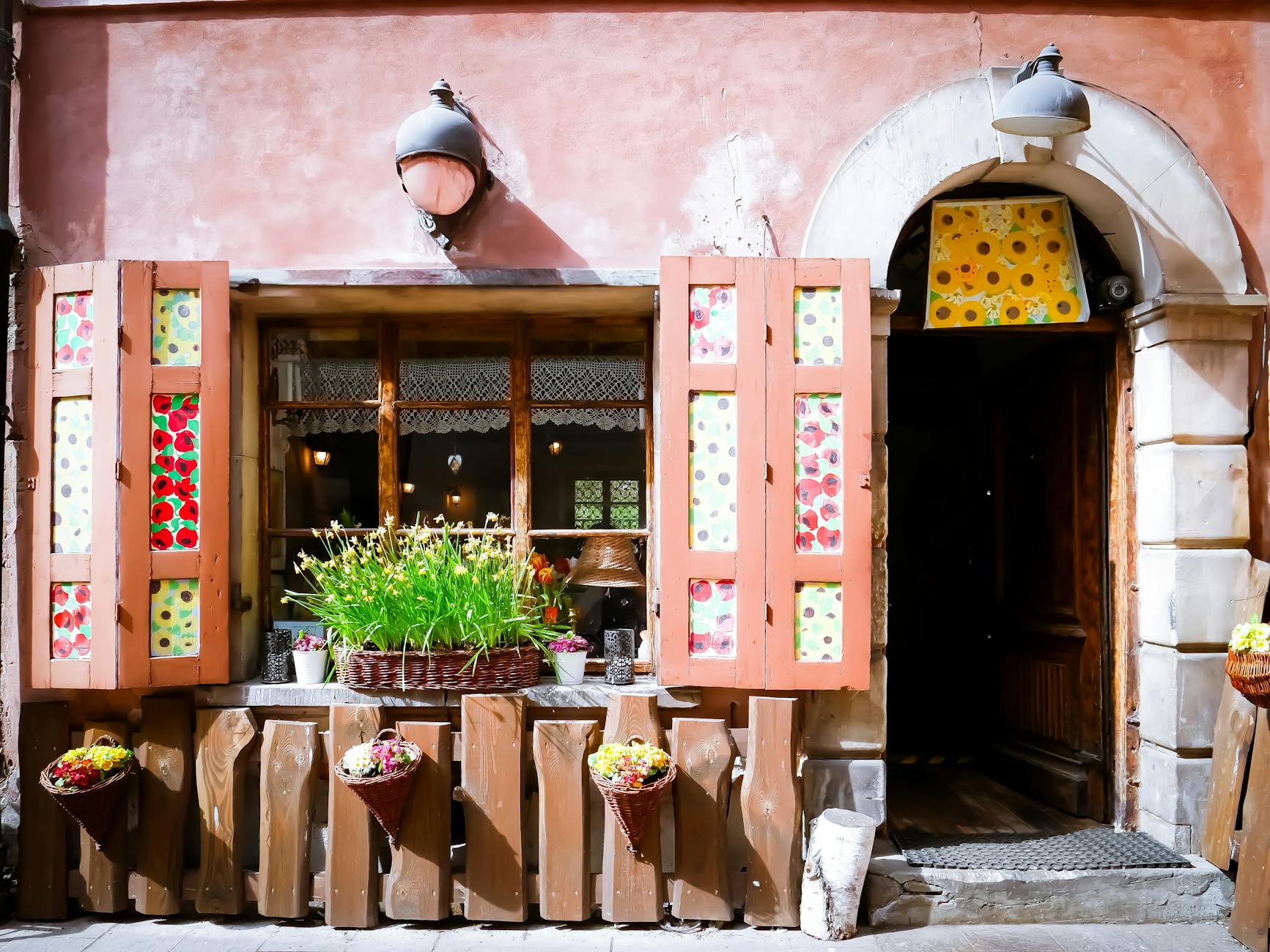 Przytulna kawiarnia z kolorowymi okiennicami i kwiatami na spokojnej ulicy